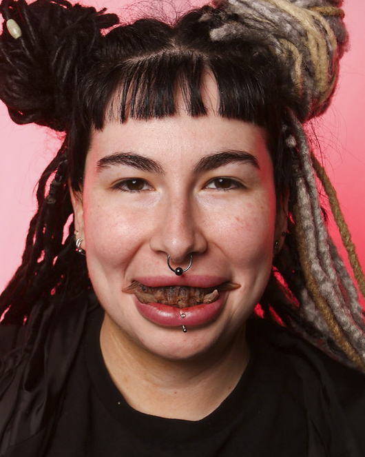 Model wearing Teeth Chiara handcrafted creature teeth and outward-facing fantasy tusks.